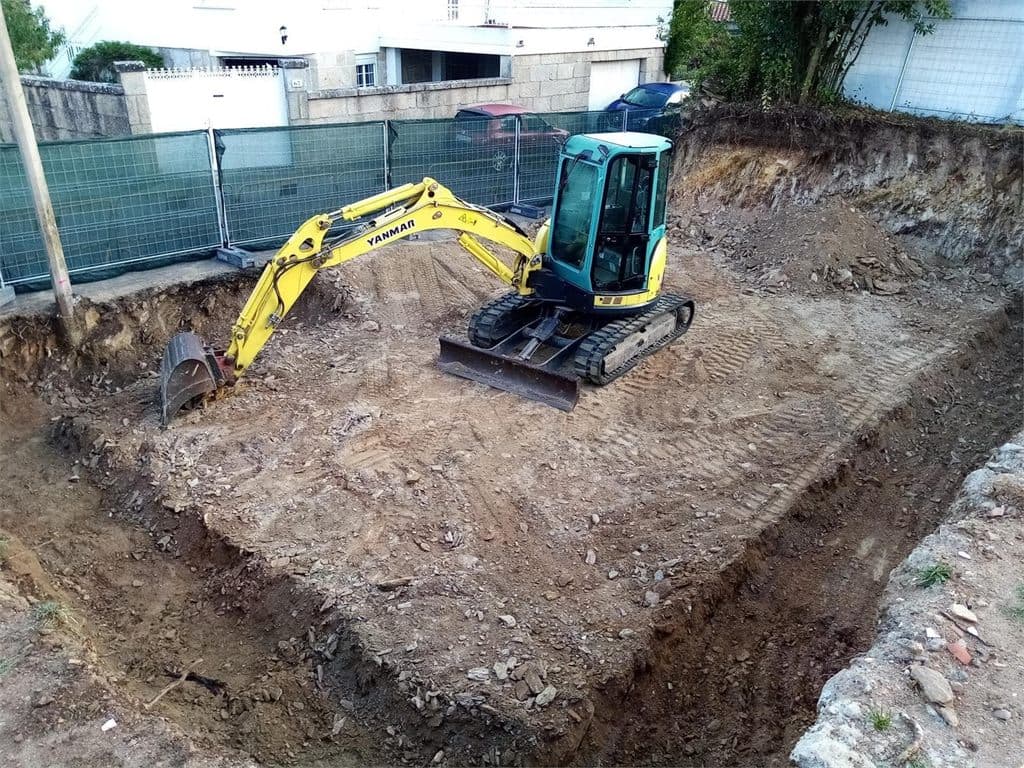 Miniexcavadora de Excavaciones Nigrán realizando el vaciado de una parcela en Nigrán