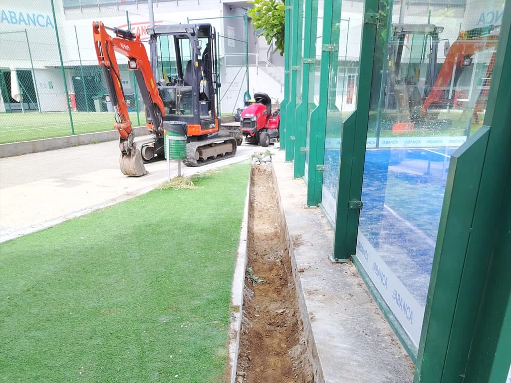 Miniexcavadora con martillo hidráulico demoliendo una solera industrial en Nigrán