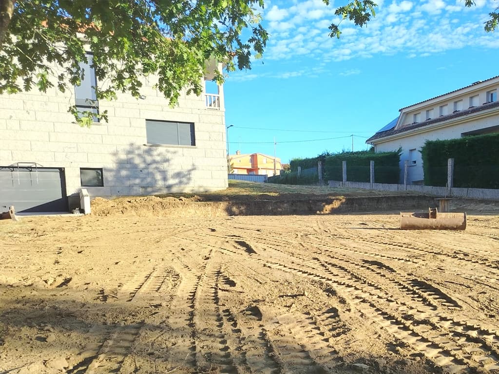 Miniexcavadora abriendo zapatas de cimentación en una parcela de Nigrán